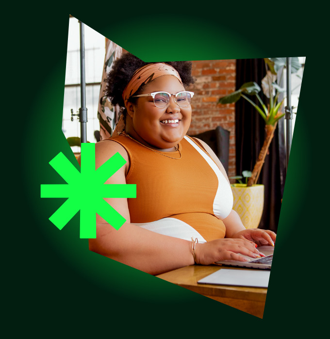 Smiling woman working on a laptop in a bright studio