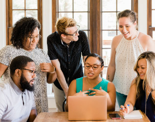 A team gathered around a laptop