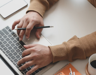 Hands typing on a laptop keyboard